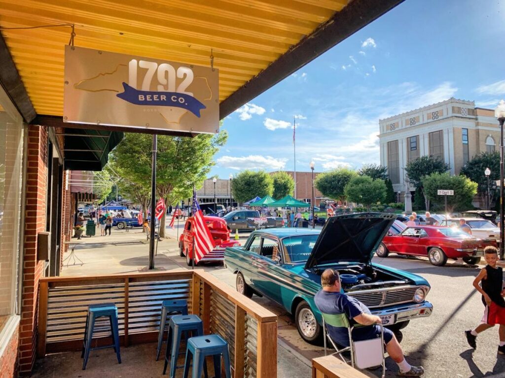 Classic cars parked on display outside a brewery