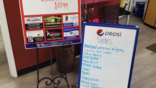 Two white boards list daily specials and beverages at a restaurant