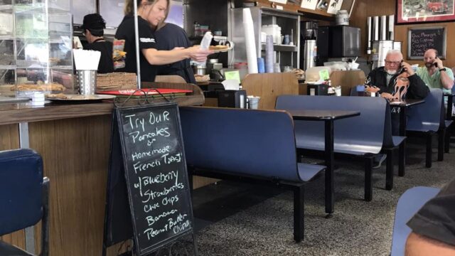 Blue tables inside a restaurant in front of the counter